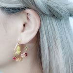 Mouse and cherry blossom hoop earrings with red bead accents, displayed on a model’s ear against a silver hair backdrop.