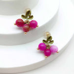 Pair of earrings with pink beads and gold accents on a white background