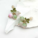 Decorative bracelet with green and pink beads on a white shell background