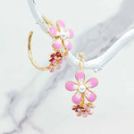 Floral earrings with pink flowers and gold accents on a white background