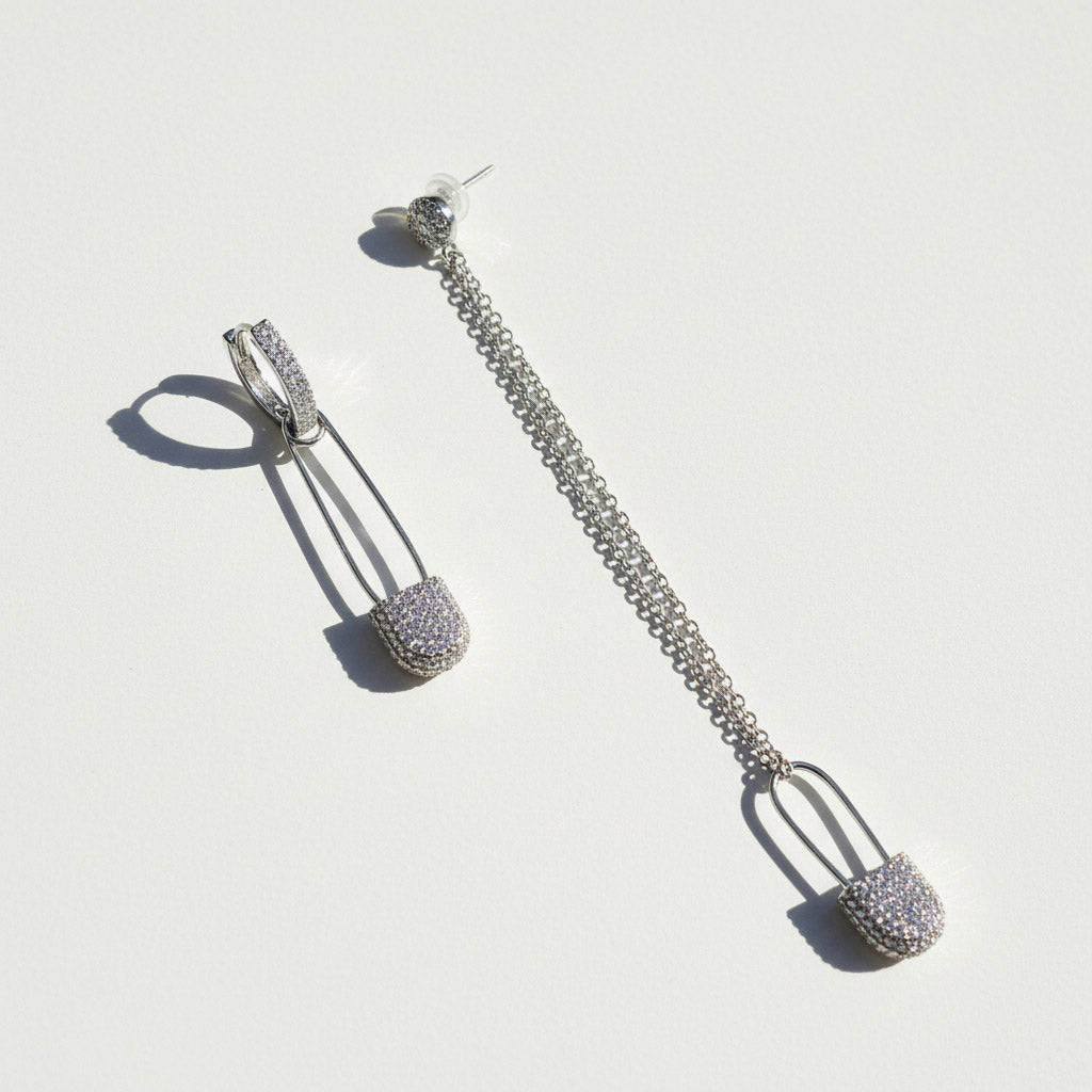 Silver chain earrings with spherical ends on a light gray background