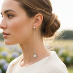 Woman wearing a silver earring with a blurred outdoor background