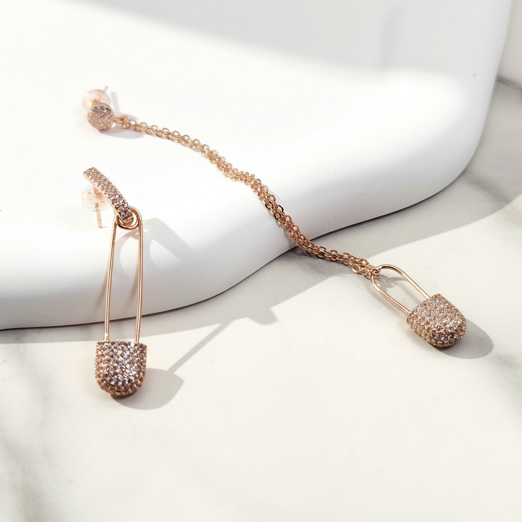 Rose gold earrings with a chain on a white surface