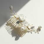 Close-up of gold bridal hair comb with porcelain flowers and freshwater pearls.