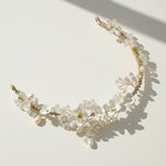 Bride wearing handcrafted porcelain and pearl tiara in garden setting.