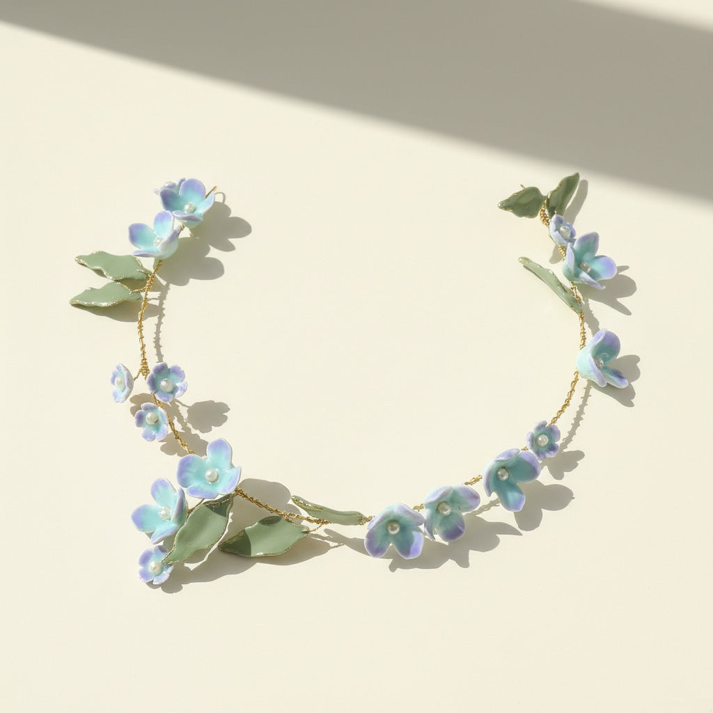 Floral headband with blue flowers and green leaves on a beige background