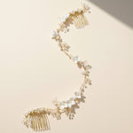 Handcrafted porcelain floral bridal hair vine with pearls and gold wire on beige background.