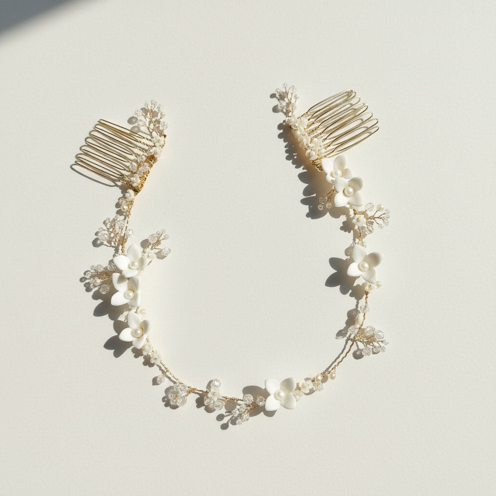 Close-up of handcrafted porcelain flowers with pearls on gold-plated vine.