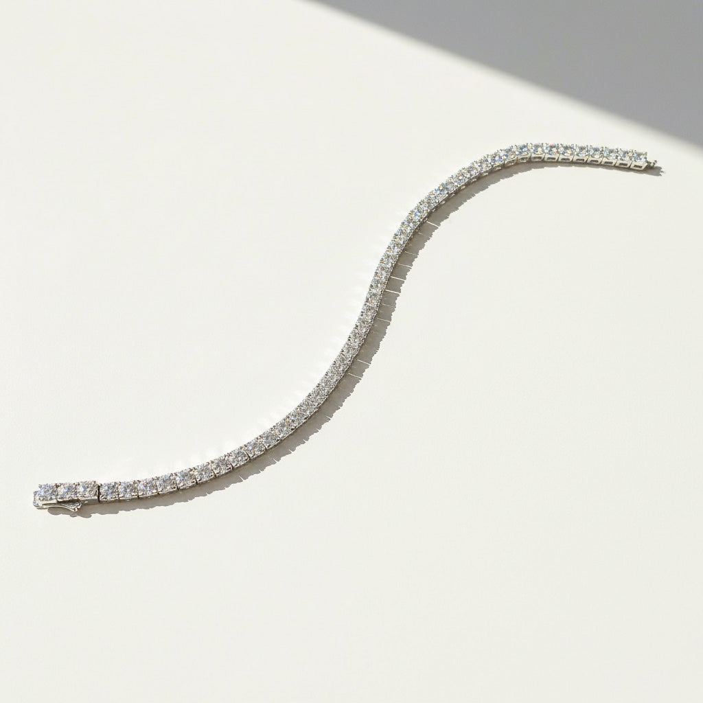 Curved moissanite tennis bracelet displayed on white surface