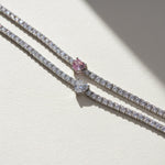 Close-up of moissanite tennis bracelets with white and pink heart center stones