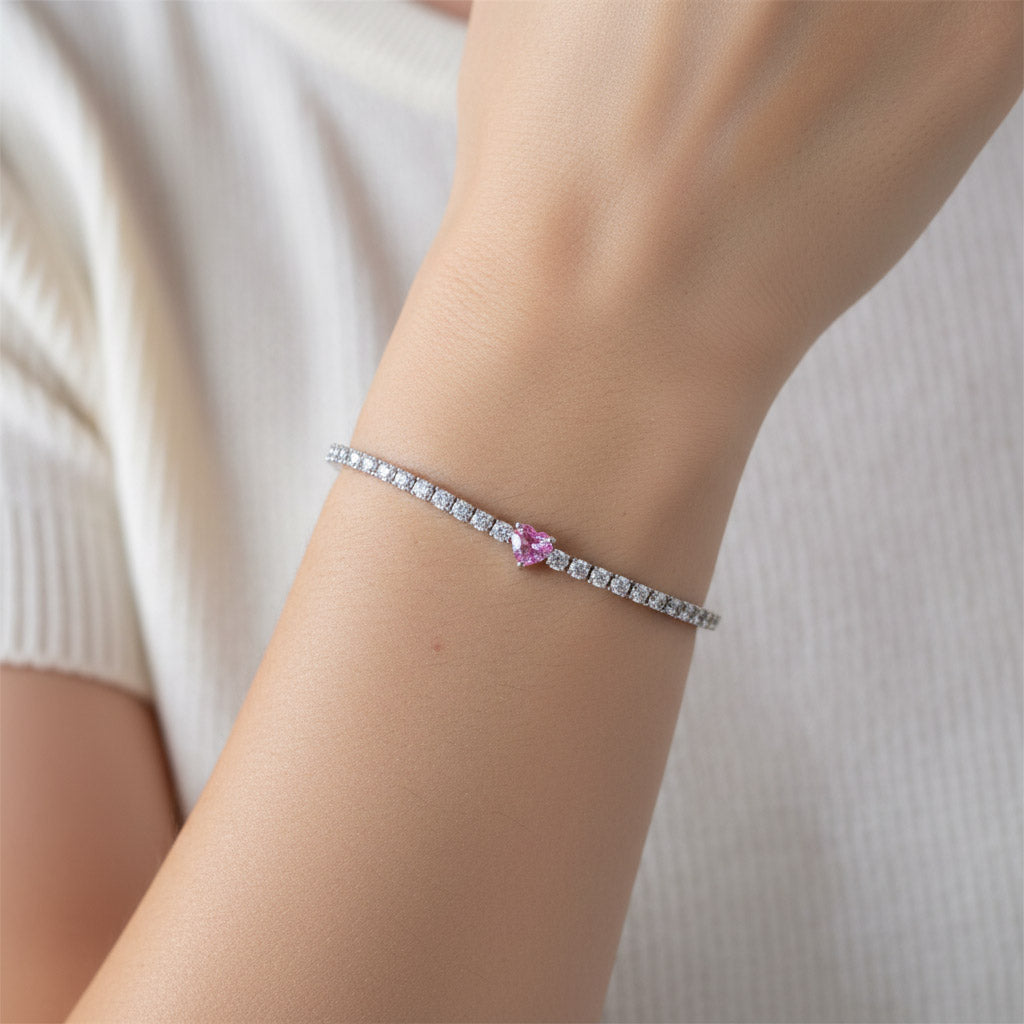 Close-up wrist view of pink heart moissanite tennis bracelet on a model