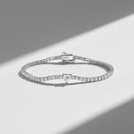 Platinum-plated silver tennis bracelet with white heart moissanite under soft sunlight