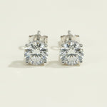 Pair of diamond stud earrings on a light beige background
