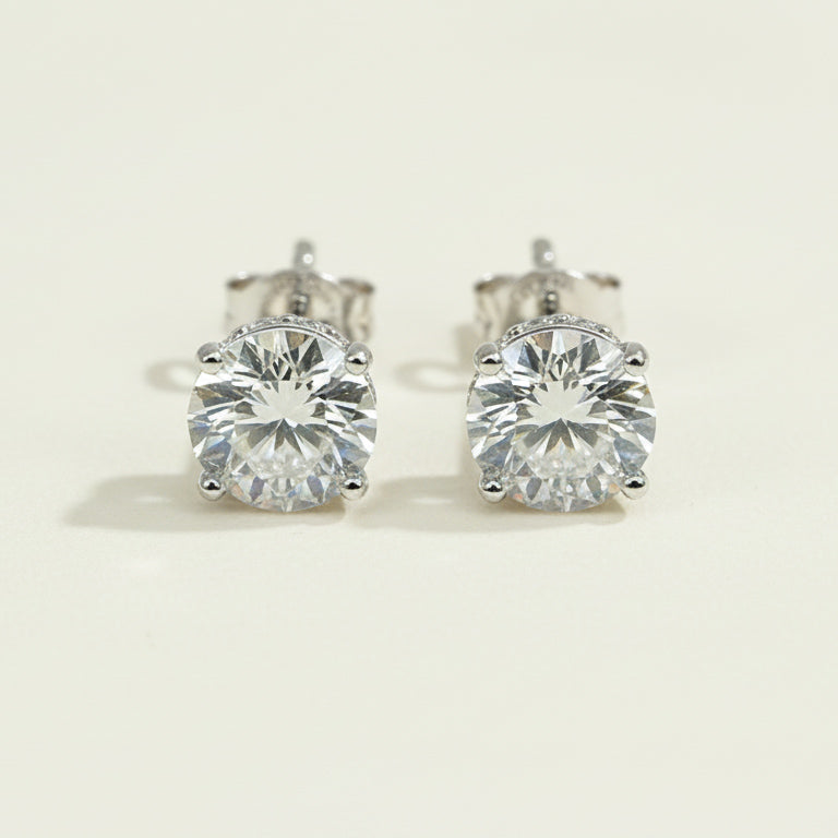 Pair of diamond stud earrings on a light beige background