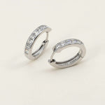 Minimalist platinum-plated sterling silver CZ hoop earrings with square-cut stones on beige background