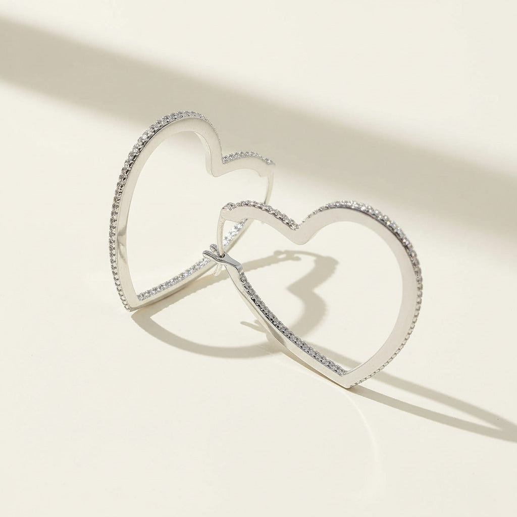 Heart-shaped sterling silver hoop earrings with sparkling pavé diamonds, open design