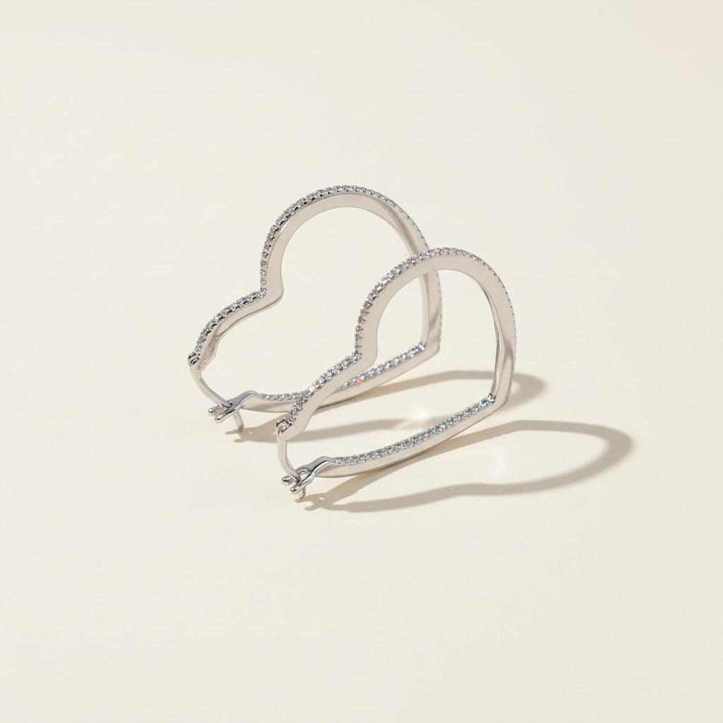 Sterling silver pavé diamond heart hoops, elegant lightweight earrings with modern silhouette.