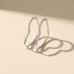 Silver hoop earrings with moissanite diamonds on a beige background
