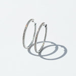 Sparkling 30mm D/VVS1 lab-grown moissanite hoop earrings photographed with natural sunlight and soft shadows.