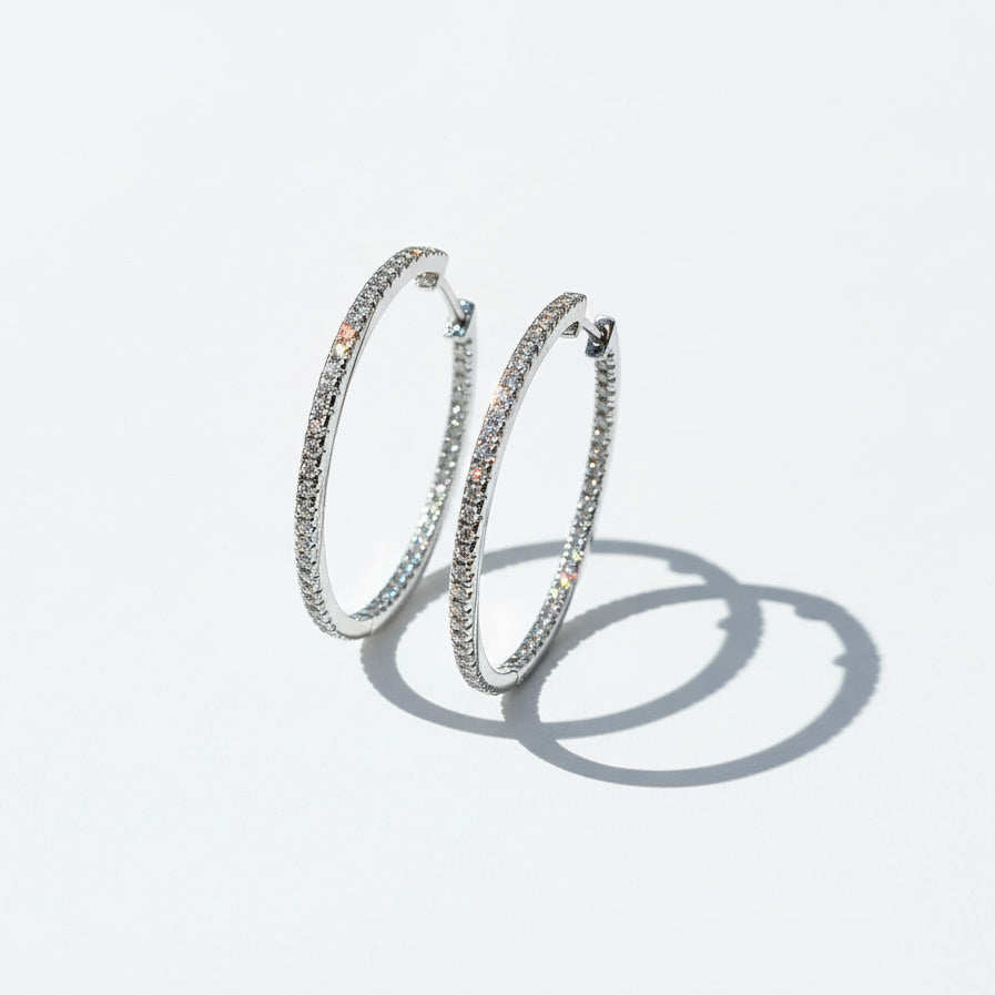 Sparkling 30mm D/VVS1 lab-grown moissanite hoop earrings photographed with natural sunlight and soft shadows.