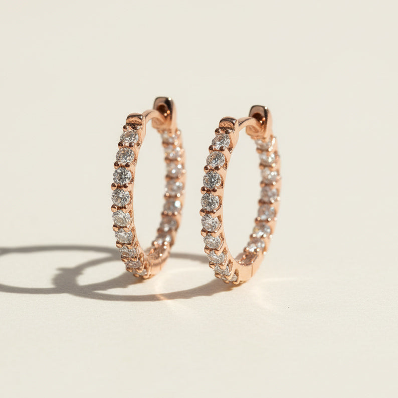 Rose gold-plated sterling silver hoop earrings with round lab-grown moissanite stones in a full pavé setting.