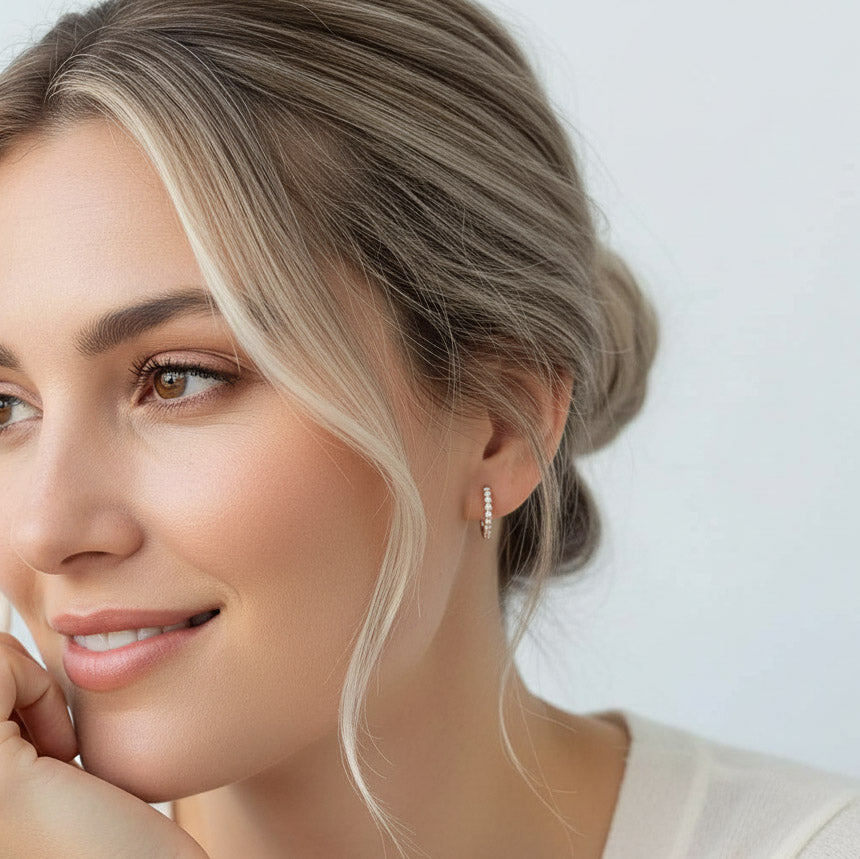 Model wearing rose gold-plated sterling silver hoop earrings with sparkling lab-grown moissanite stones.