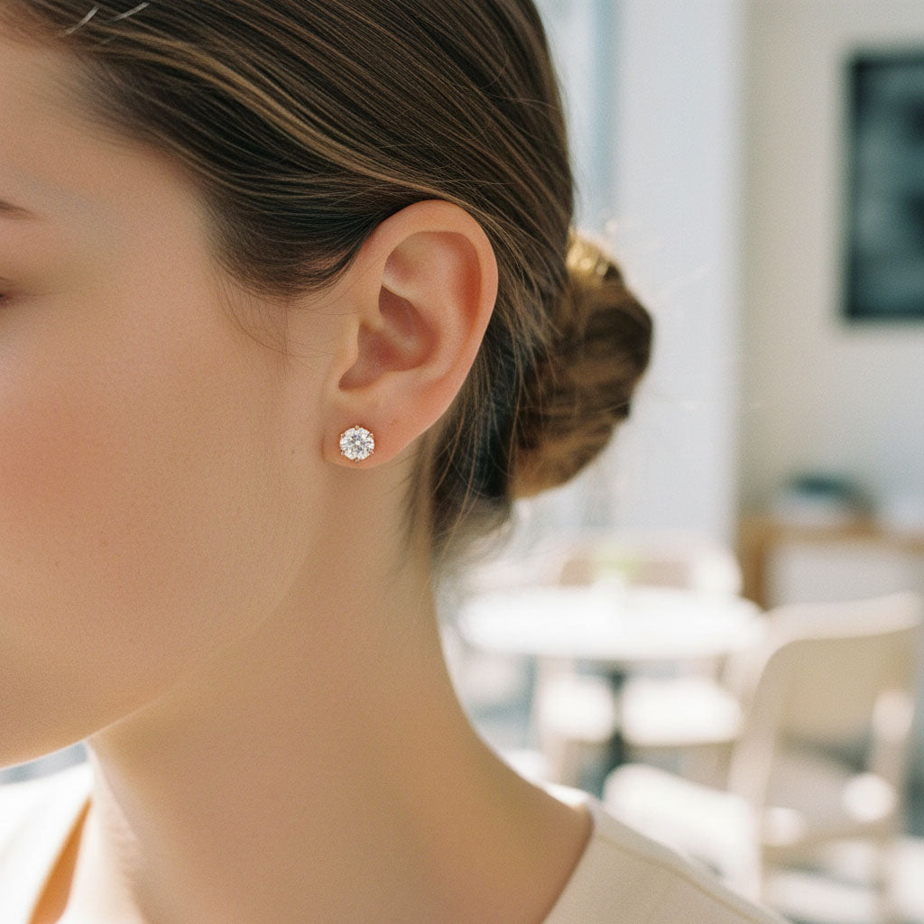 Rose gold-plated S925 stud earrings with 2ct total lab-grown Portuguese-cut diamonds shown on ear by A2K London.