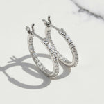 Platinum-plated sterling silver hoop earrings with inside-out moissanite stones.