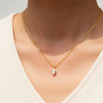 Close-up of 1ct marquise D/VVS1 moissanite pendant on a gold-plated chain in sunlight