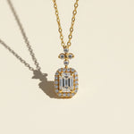 Close-up of emerald-cut moissanite halo pendant with floral accent in gold-plated silver