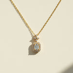Gold-plated emerald-cut D/VVS1 moissanite halo necklace displayed under sunlight