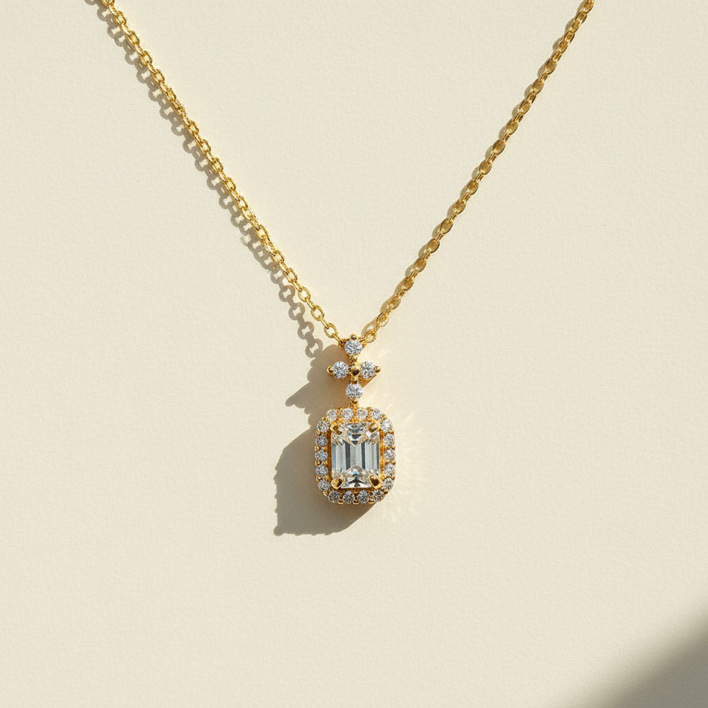 Gold-plated emerald-cut D/VVS1 moissanite halo necklace displayed under sunlight