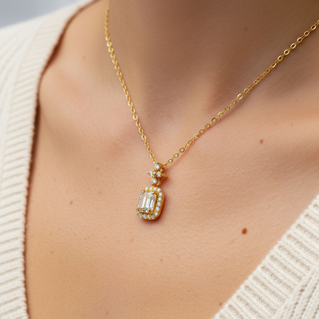 Gold necklace with a diamond pendant worn by a person