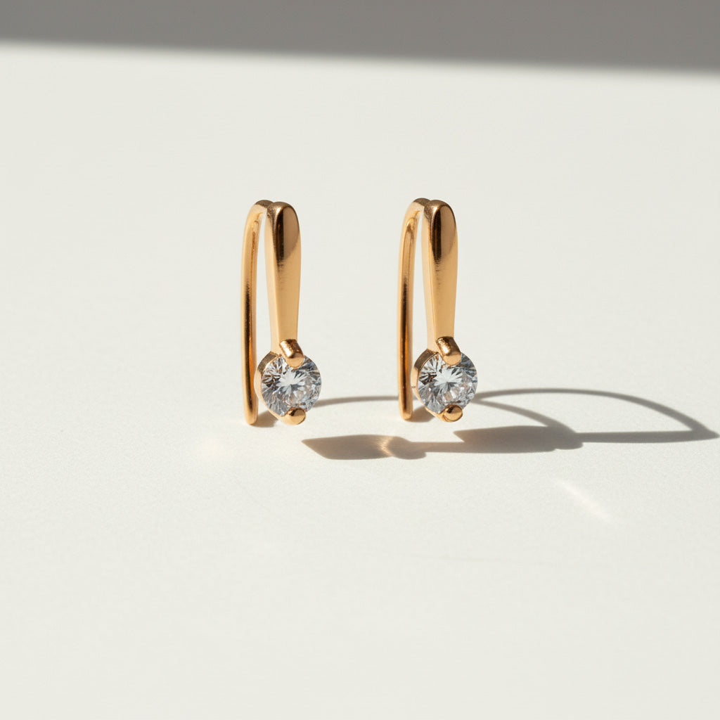 Gold-plated moissanite drop huggie earrings with 0.1ct D/VVS1 stones on light background