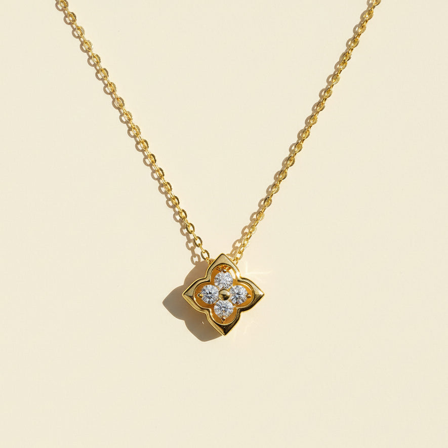 Gold-plated moissanite clover necklace with four 3mm stones on a soft background