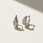 Sterling silver leaf-shaped moissanite hoop earrings on a light background