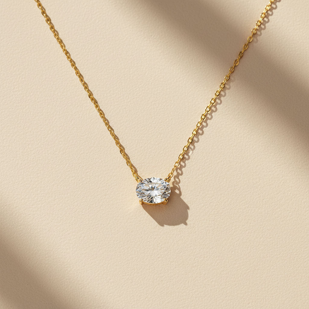 2ct gold moissanite pendant necklace in sunlight on beige surface