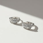Close-up of sterling silver leaf design moissanite hoop earrings