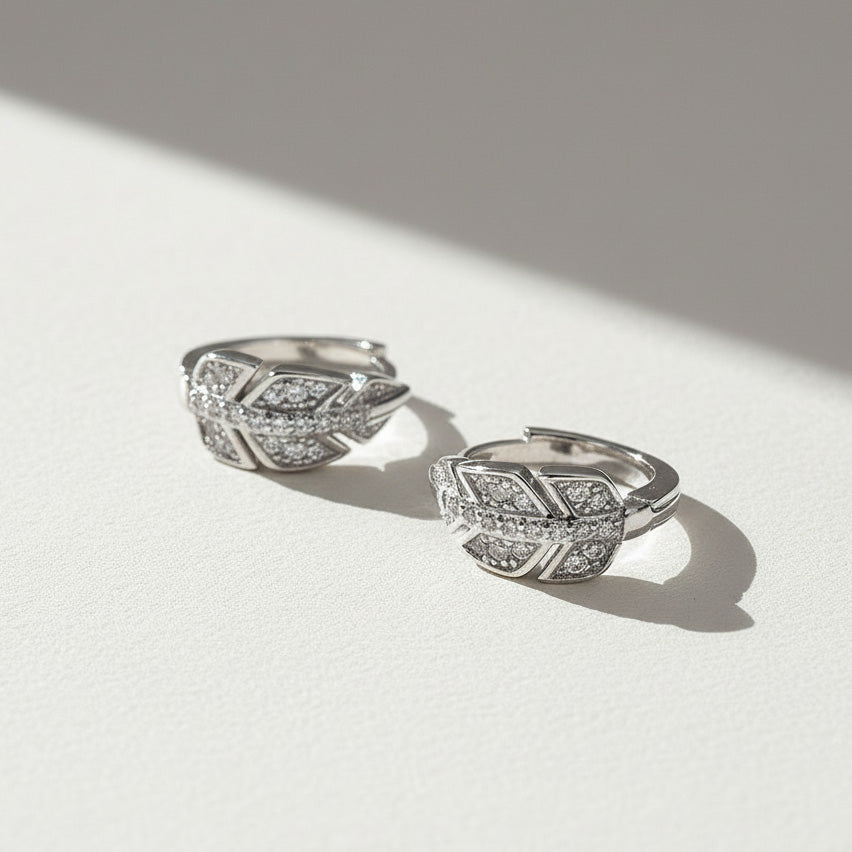 Close-up of sterling silver leaf design moissanite hoop earrings