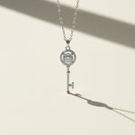 Close-up of moissanite key pendant necklace on light background