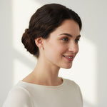 Woman wearing emerald-cut moissanite stud earrings in silver for an elegant look