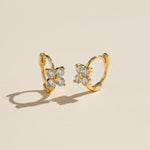Close-up of gold moissanite floral huggie earrings with sparkling 3mm stones