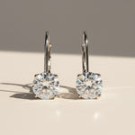 Front view of round brilliant 1ct moissanite lever-back earrings in silver.
