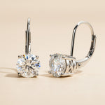 Pair of diamond earrings on a beige background