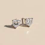Heart-shaped 1ct lab diamond moissanite stud earrings on beige background