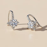 Silver star moissanite earrings with 1ct round stones under natural light