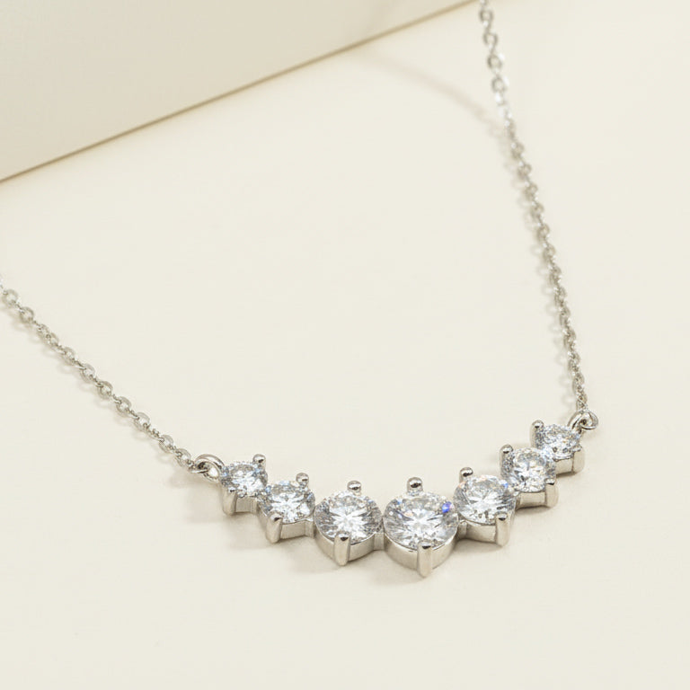 Sterling silver necklace with seven round lab-grown diamonds in a curved bar design