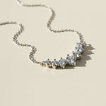 Silver necklace with moissanite stones on a beige background