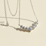 Silver necklace with moissanite diamond stones on a beige background