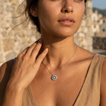Woman wearing a moissanite diamond necklace with a scenic background